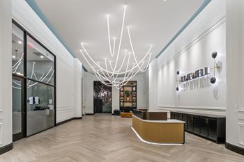 A reception area with a white reception desk and a large chandelier.
